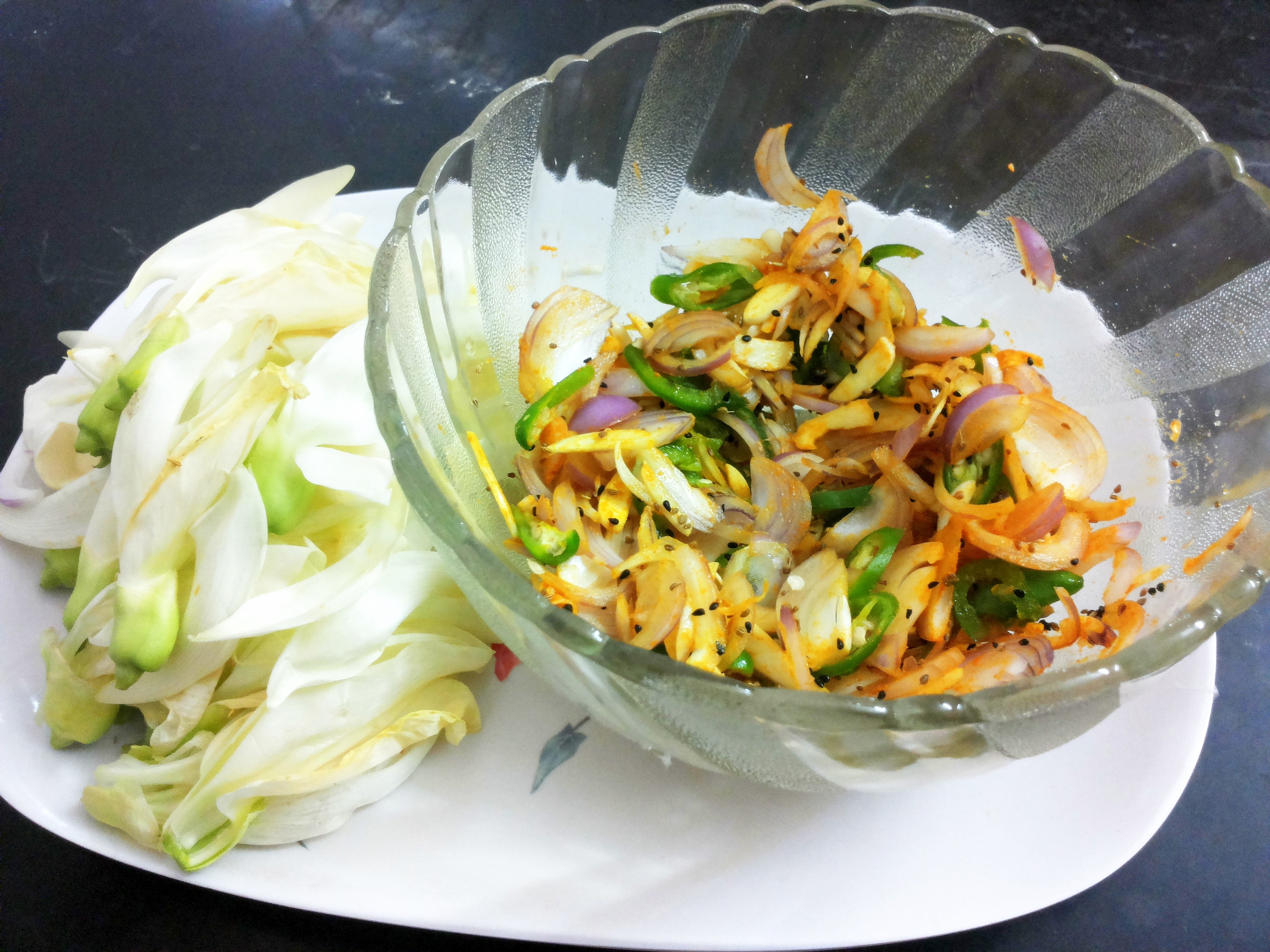 sliced onion, garlic and green chili along with salt, Ajawine, Kalongi, and black pepper