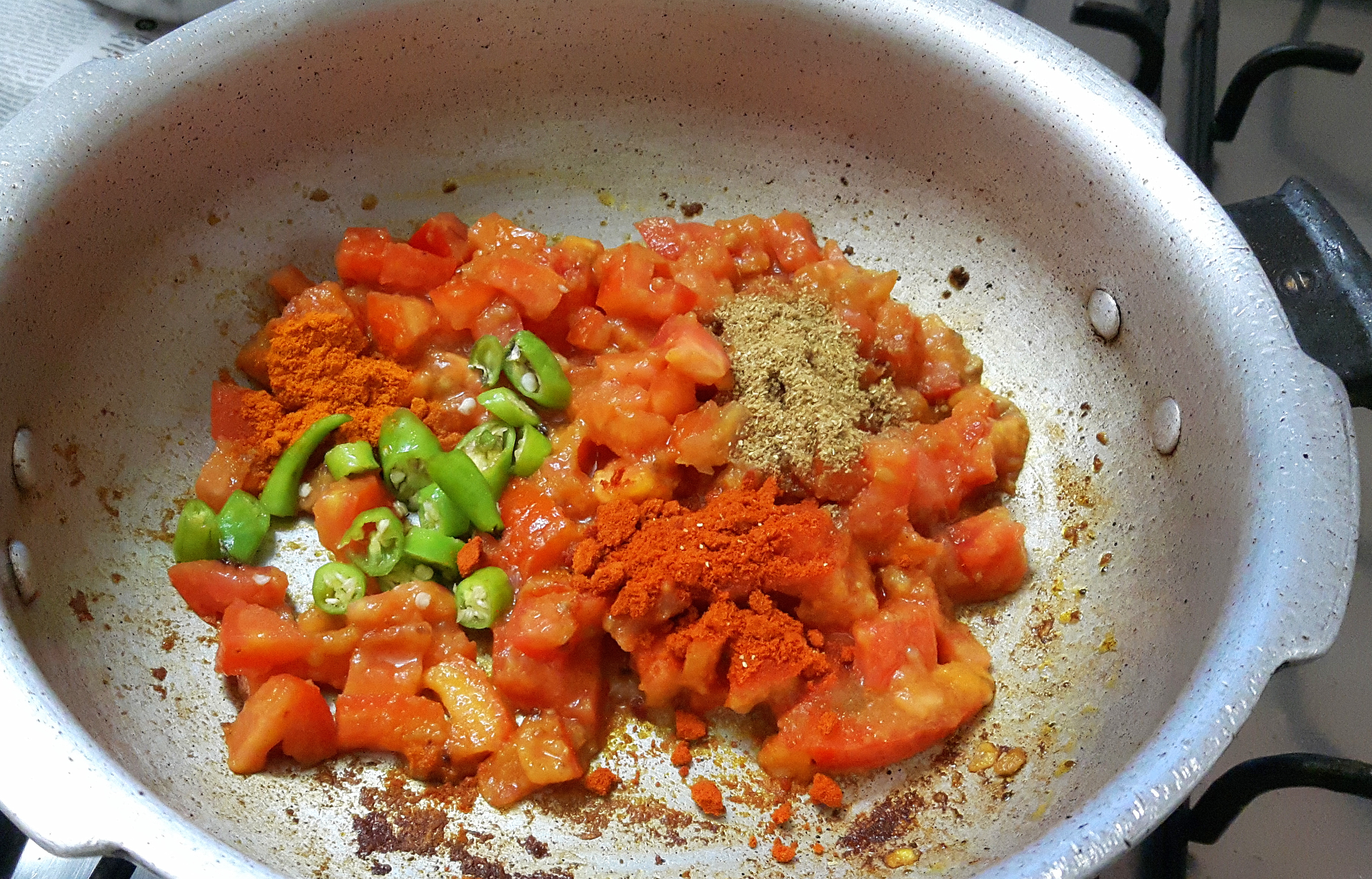 add chopped tomatoes, chopped green chili, and powder masala
