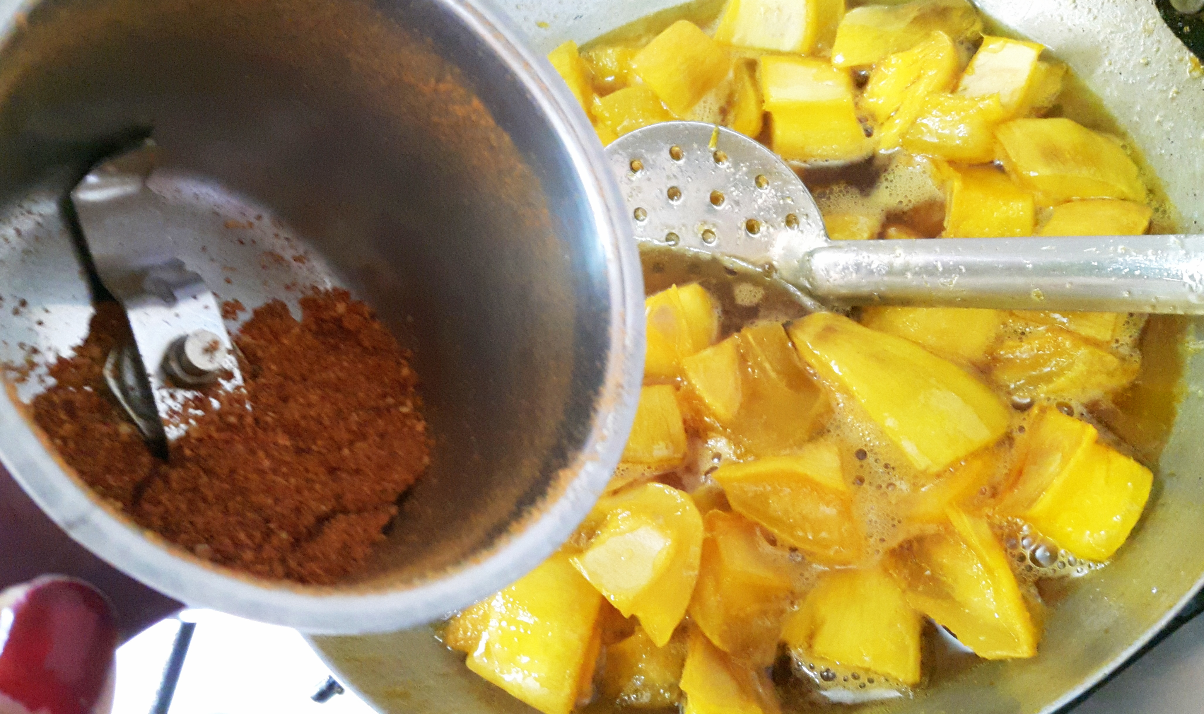 Add the mango pieces and asafoetida, roasted fenugreek powder & chili powder