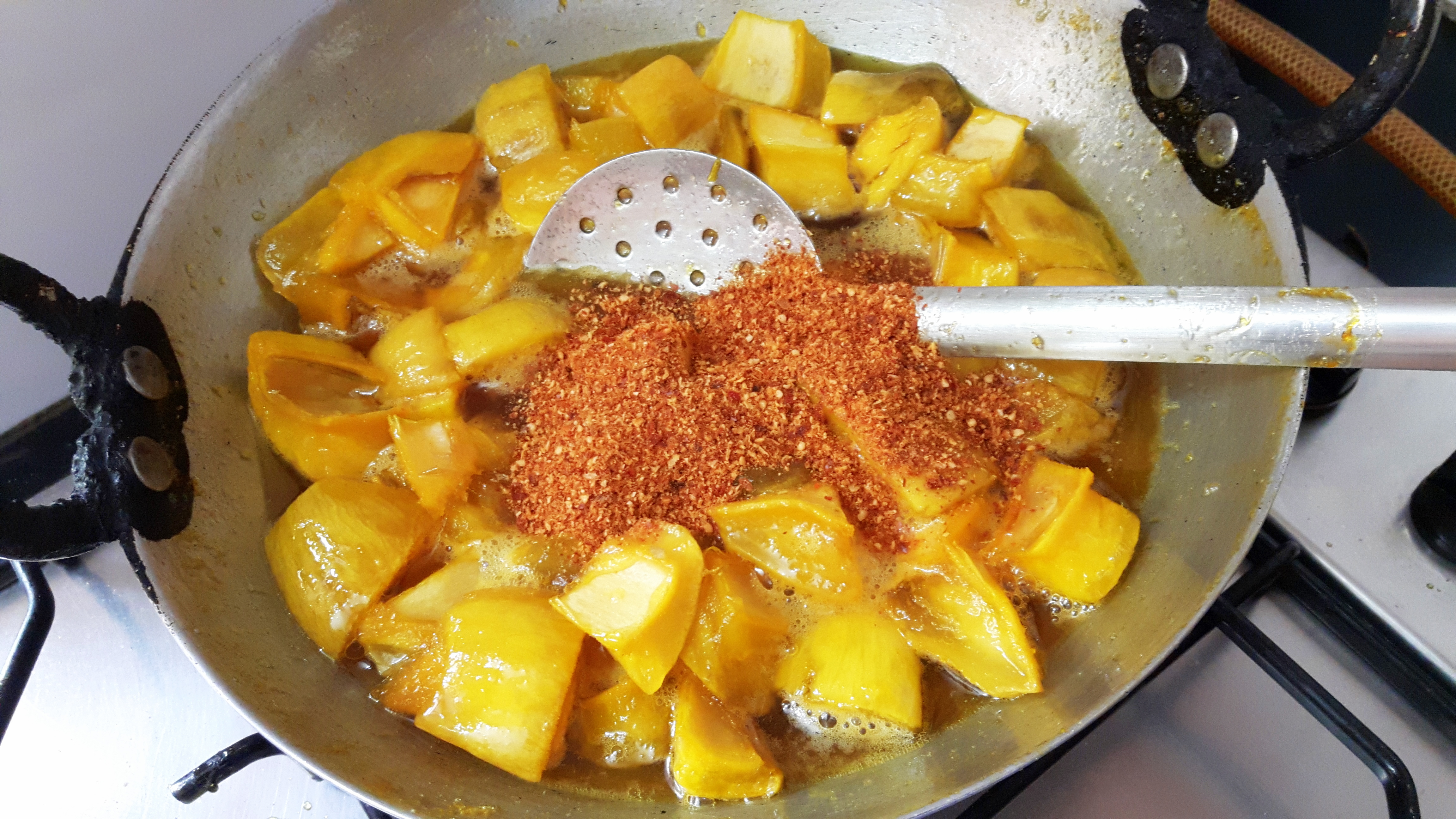 Add the mango pieces and asafoetida, roasted fenugreek powder & chili powder