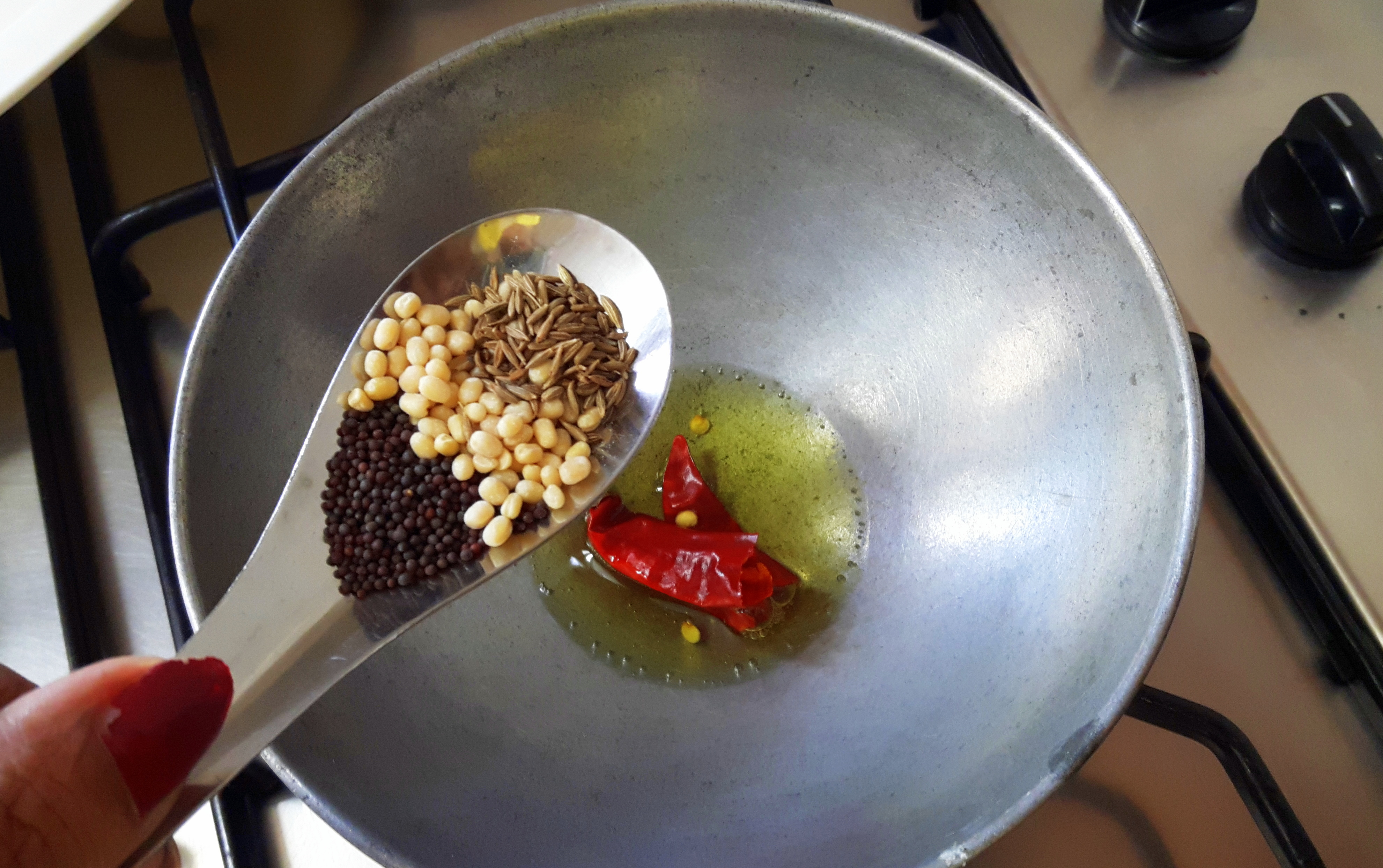 add mustard seed, whole red chili, split black gram cumin and sliced coconut