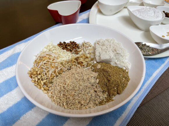 In a mixing bowl add ground coriander, makhane, dry fruits  