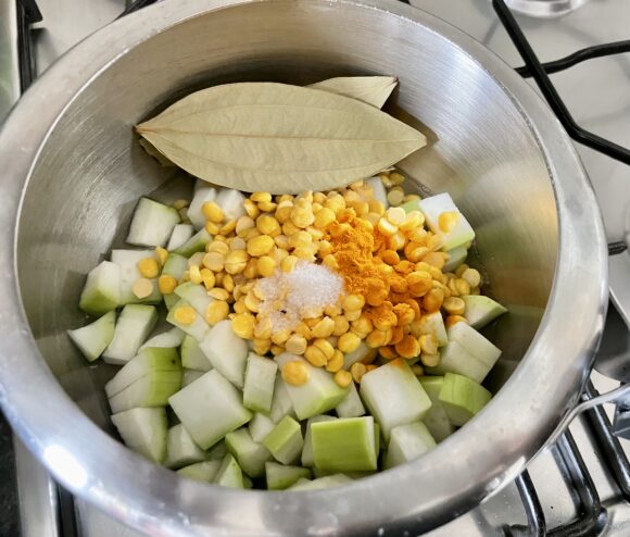 Put dal, lauki, chana dal, salt, turmeric powder and bay leaf along with water in the pressure cooker on high flame
