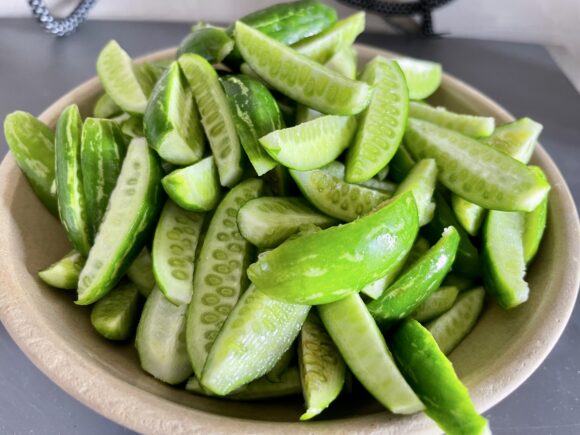 Trim the both ends of Kundru (Ivy gourd), chop logitudinally into 2-3 pieces, 