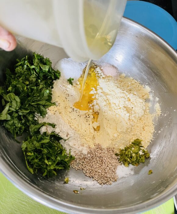 In a big mixing bowl; add chopped Methi leaves, coriander leaves, along with all Muthia ingredients.