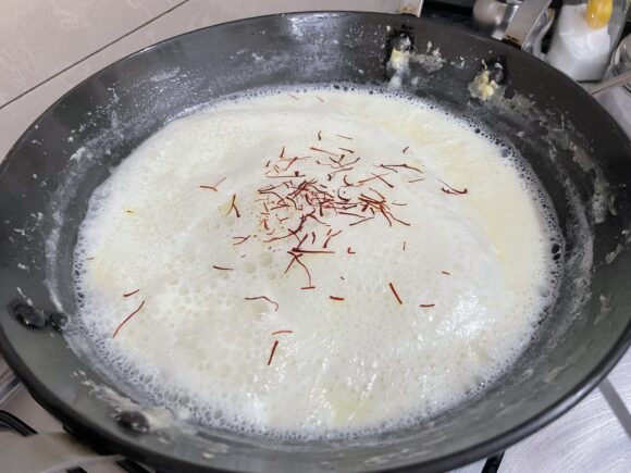 stirring and mixing the malai layer that forms on the top of the milk.  