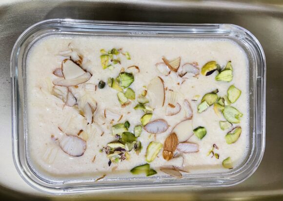 Transfer into serving bowl; decorate with sliced almond and pistachio